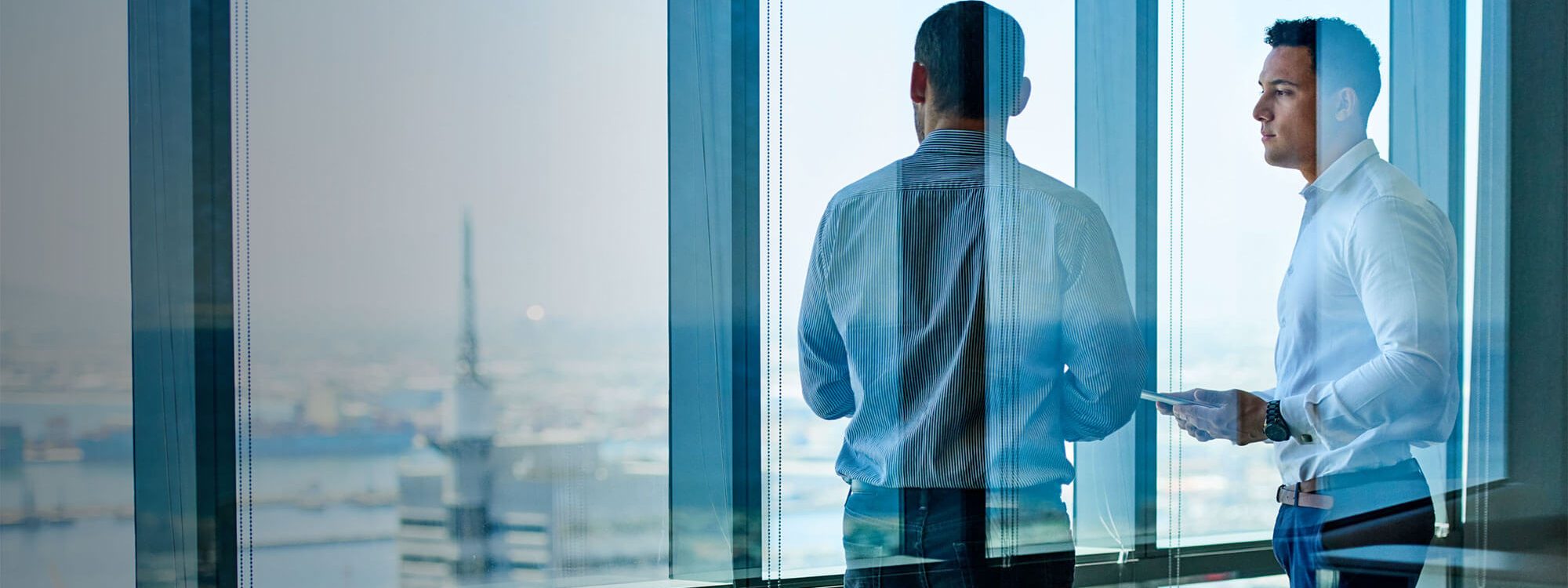 two men standing by window